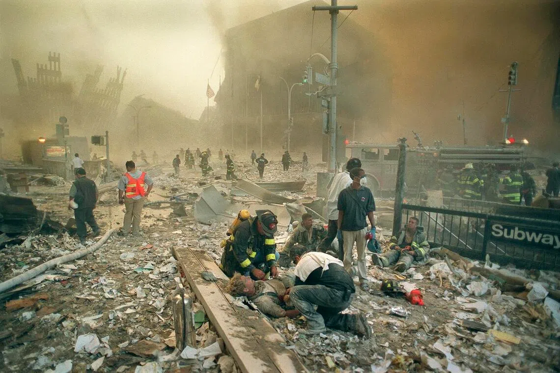 Firefighters and paramedics assist the injured in the immediate aftermath of the collapse of the twin towers of the World Trade Center on Sept. 11, 2001.