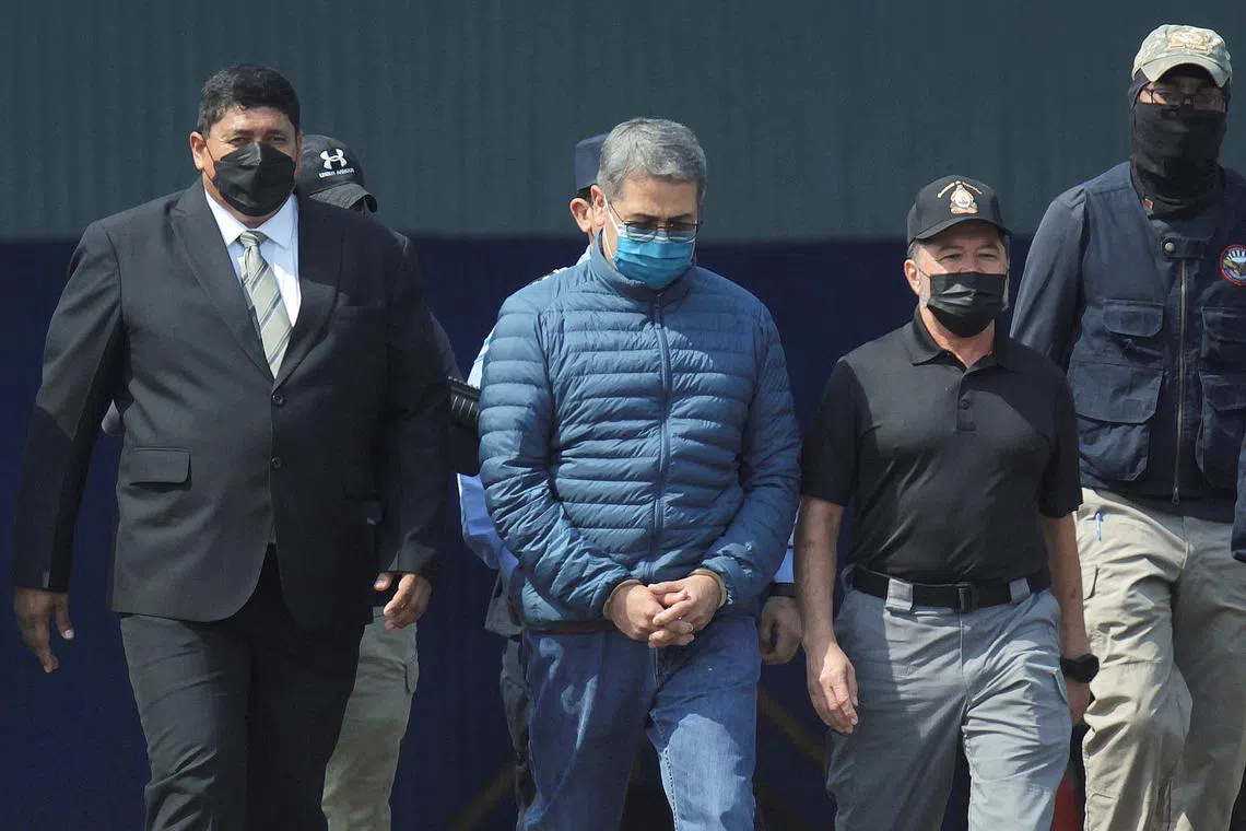 FILE PHOTO: Honduras former President Juan Orlando Hernandez is escorted by authorities as he walks towards a plane of the U.S. Drug Enforcement Administration (DEA) for his extradition to the United States, to face a trial on drug trafficking and arms possession charges, at the Hernan Acosta Mejia Air Force base in Tegucigalpa, Honduras April 21, 2022. REUTERS/Fredy Rodriguez/File Photo