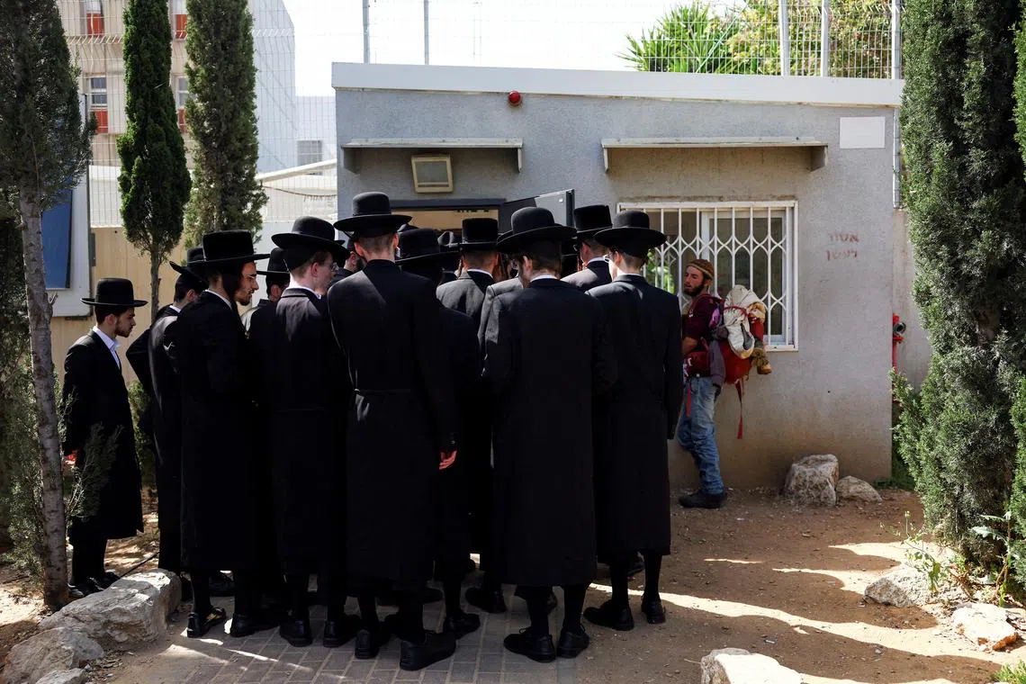 FILE PHOTO: Ultra-Orthodox Jews line up at an Israeli draft office to process their exemptions from mandatory military service at a recruitment base in Kiryat Ono, Israel March 28, 2024. REUTERS/Hannah McKay/File Photo