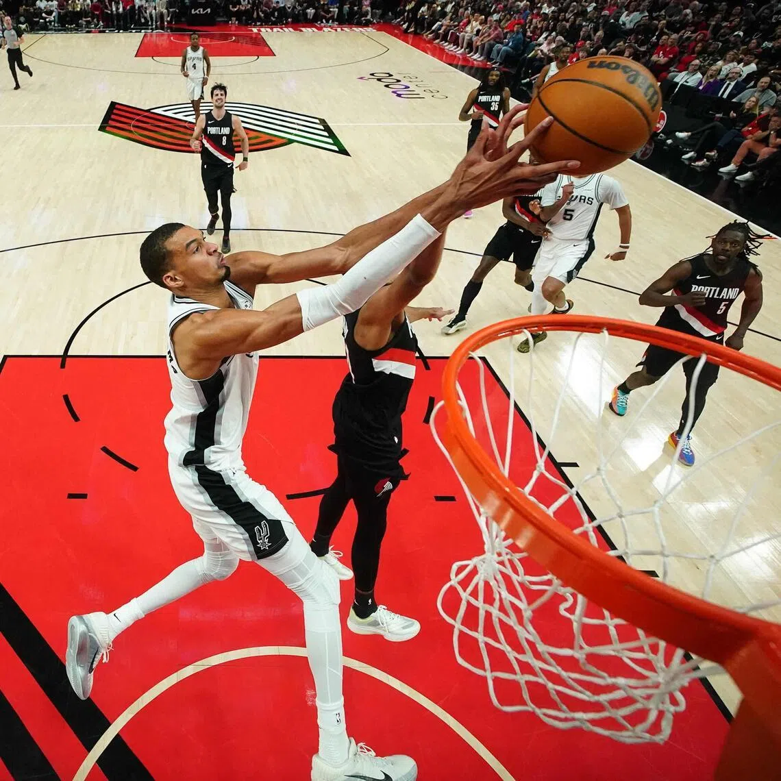 Victor Wembanyama of the San Antonio Spurs attempts a dunk against Kris Murray of the Portland Trail Blazers during the second half of Game 4.