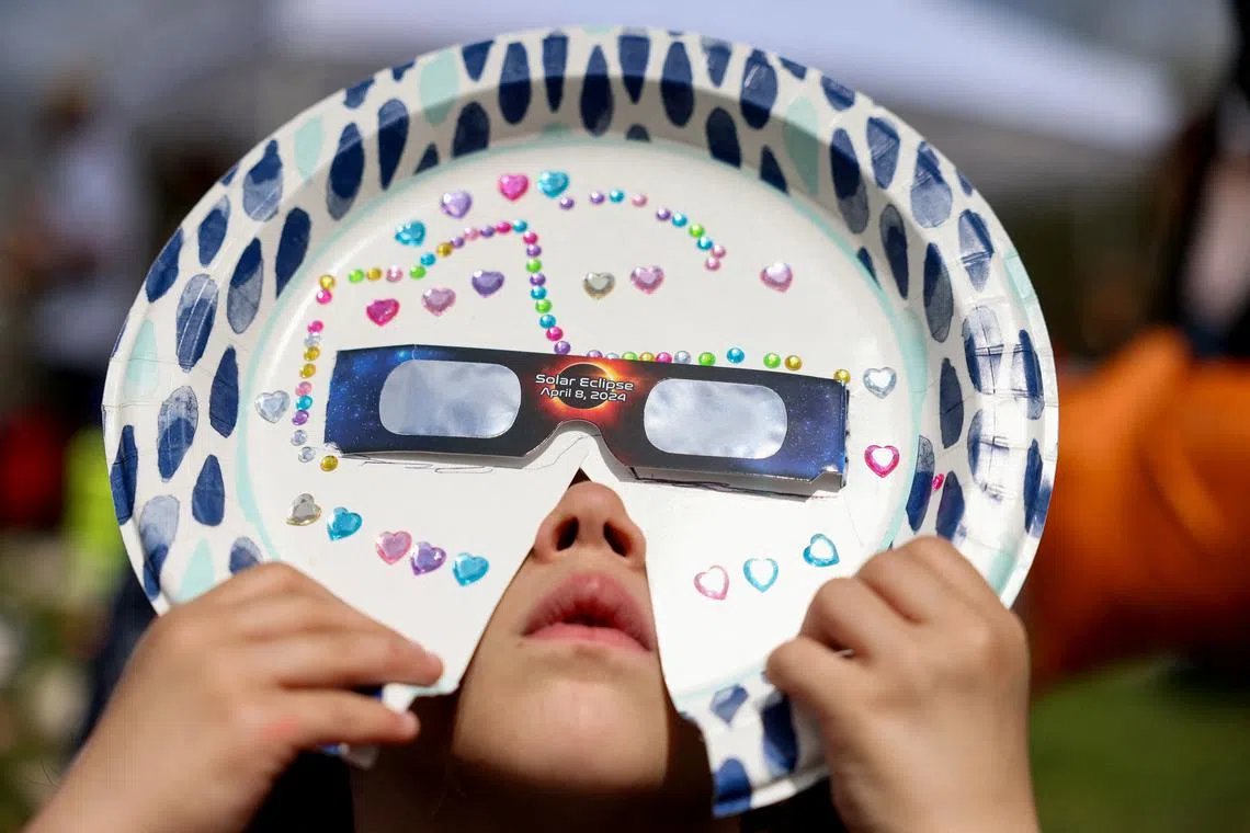 Sophia Moccia, 4, from Queens, viewing the solar eclipse with a homemade mask, at New York Hall of Science in New York City, on April 8, 2024. 