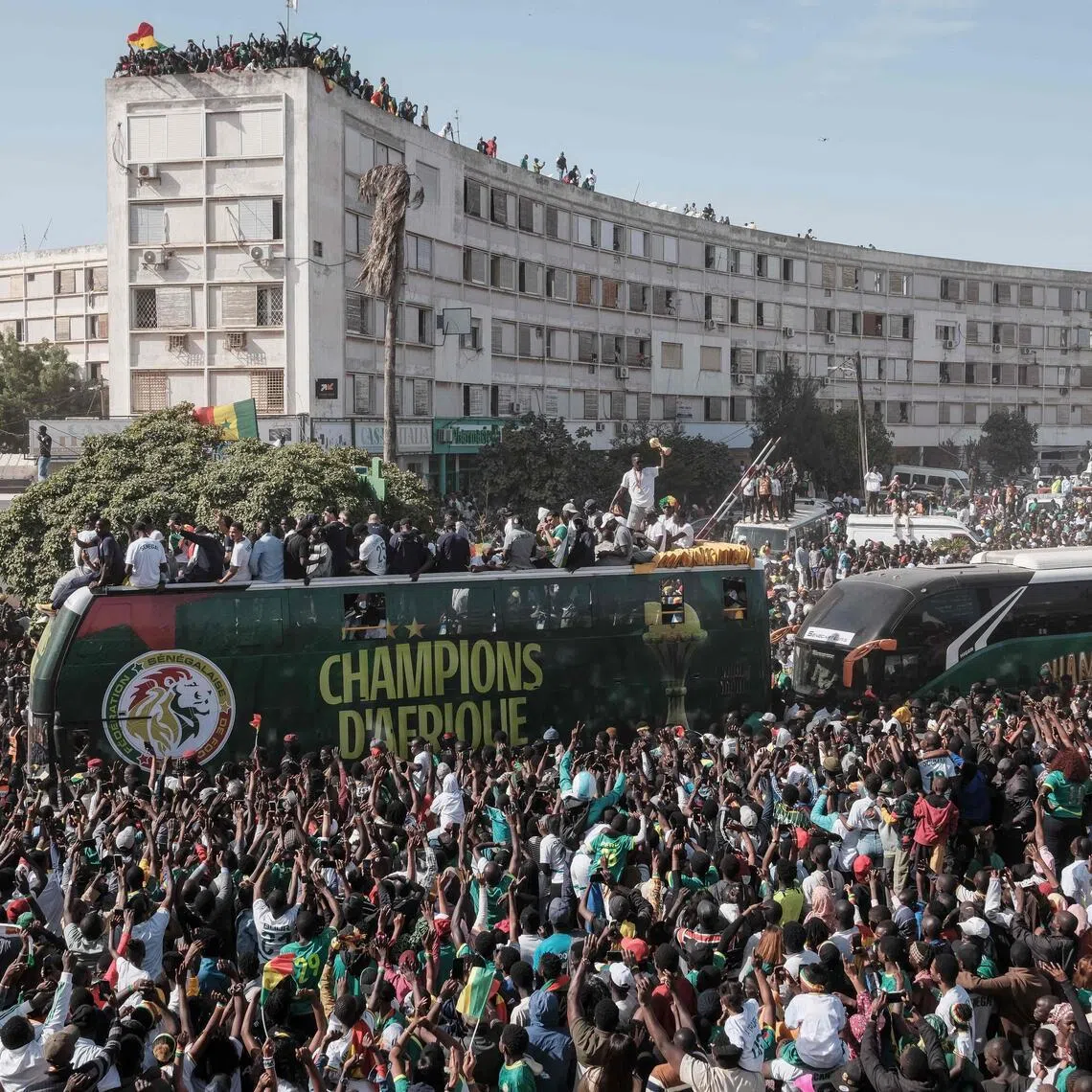Senegal supporters cheering as the country's footballers ride on a bus during a trophy parade in the streets of Dakar on Jan 20, 2026 as they celebrate winning the Africa Cup of Nations that was hosted in Morocco.