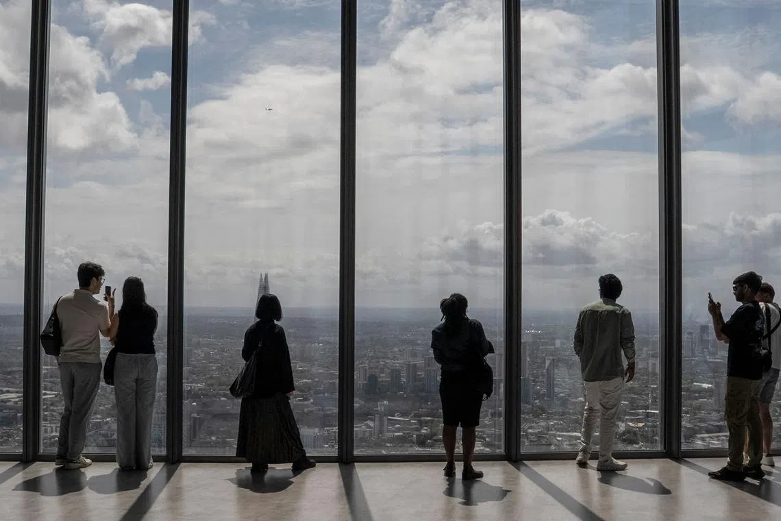 People taking in the view of London from the top of a skyscraper, on July 15, 2025.