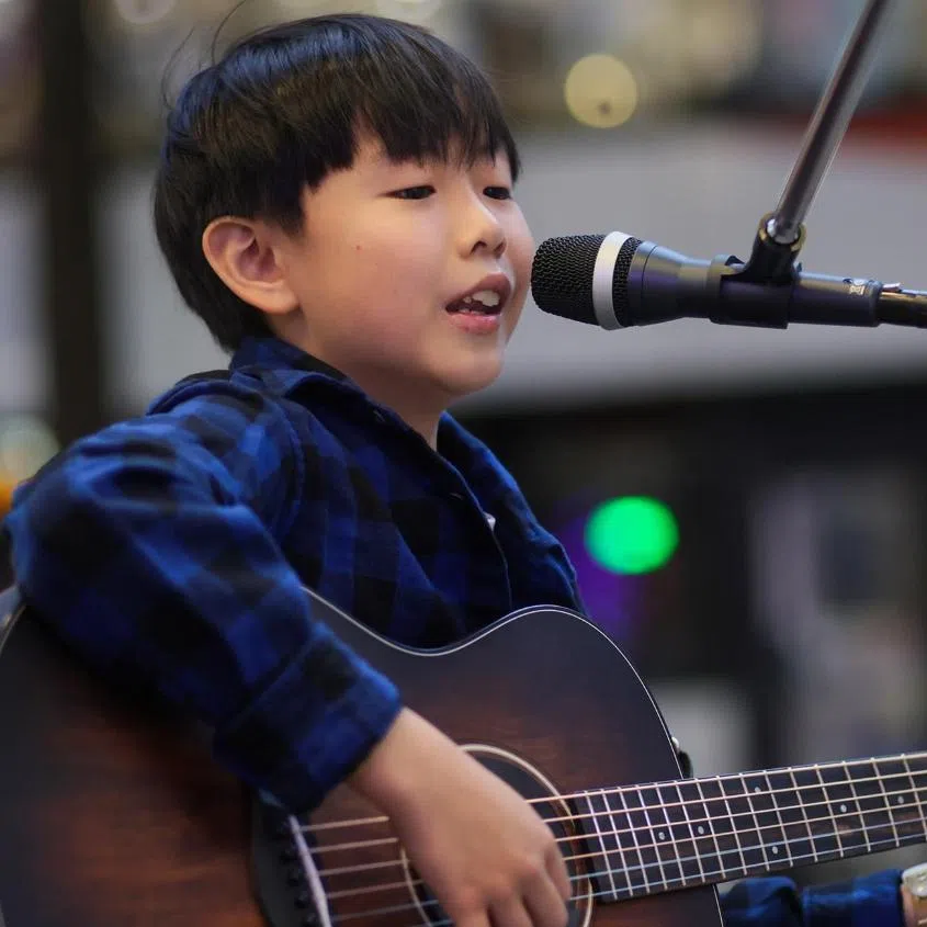 Shayne Ko (left) and Elijah Seah, both 10, play instruments and sing outside MRT stations and malls.