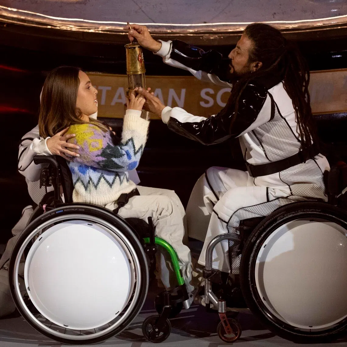 Performers extinguishing the Paralympic flame during the closing ceremony of the 2026 Milano-Cortina Paralympic Winter Games in Cortina d'Ampezzo on March 15, 2026.