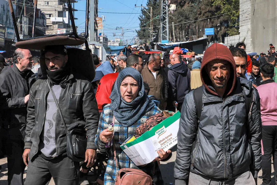 People walk along a crowded main street in Rafah, in the southern Gaza Strip.