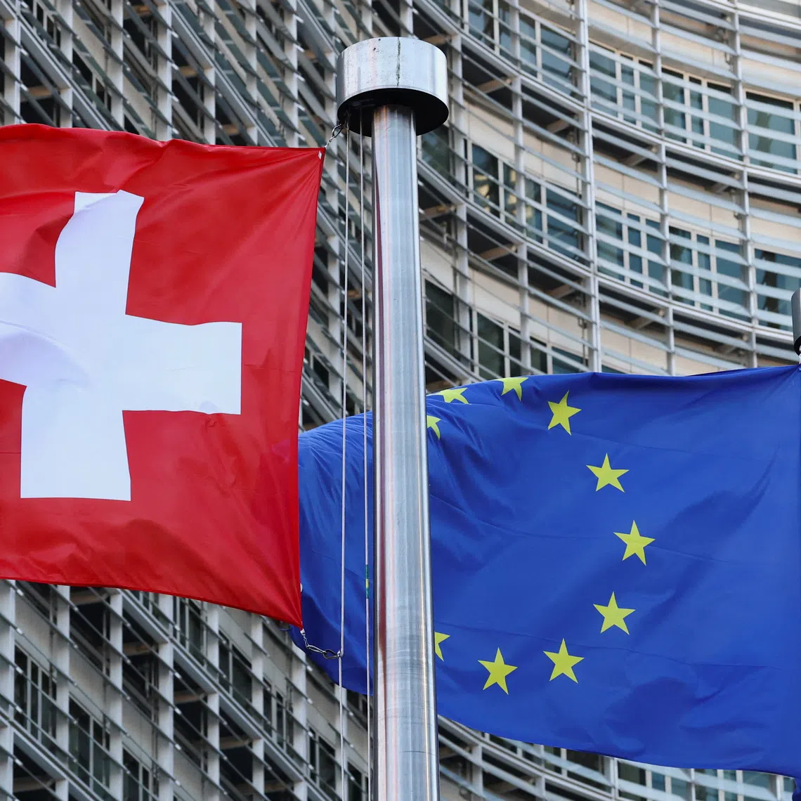 Switzerland's national flag flies beside the flag of the European Union in Brussels, Belgium, March 2, 2026. REUTERS/Yves Herman