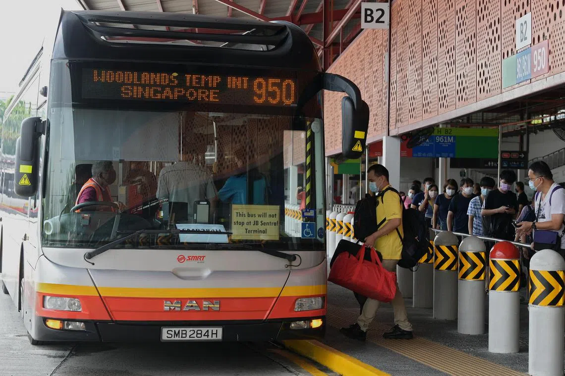 Commuters boarding service 950 at Woodlands Temporary Bus Interchange as cross-border bus services between Singapore and Malaysia resumed on 1 May 2022. Such bus services had been suspended since 2020, when the Covid-19 pandemic forced the two countries to close their land borders.