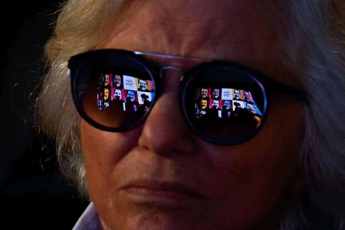 A woman looks at a screen showing images of the late former President (1983-1989) Raul Alfonsin during the celebration of the 40th anniversary of the return of democracy and his election, on Oct 30, in Buenos Aires.