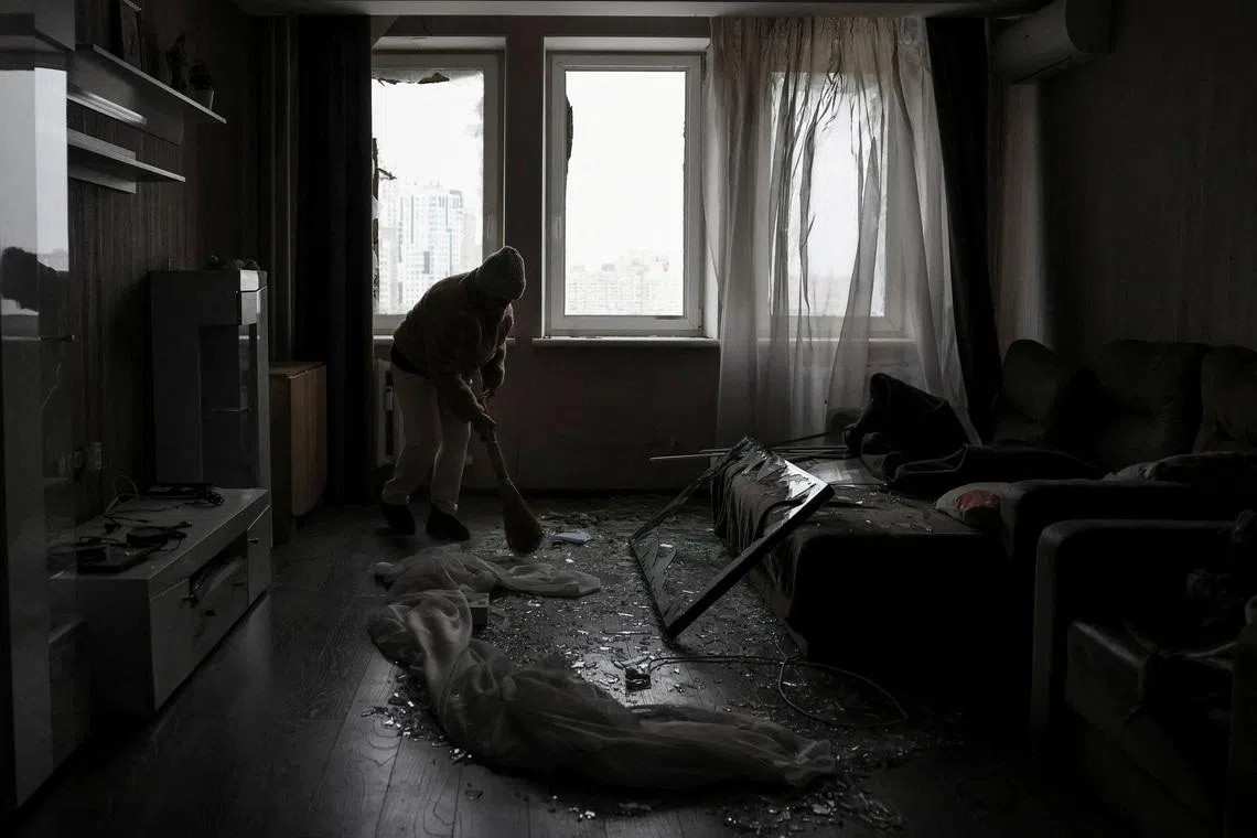 FILE PHOTO: A resident cleans her flat in an apartment building damaged by a Russian drone strike, amid Russia's attack on Ukraine, in Kyiv, Ukraine January 9, 2026. REUTERS/Anatolii Stepanov/File Photo
