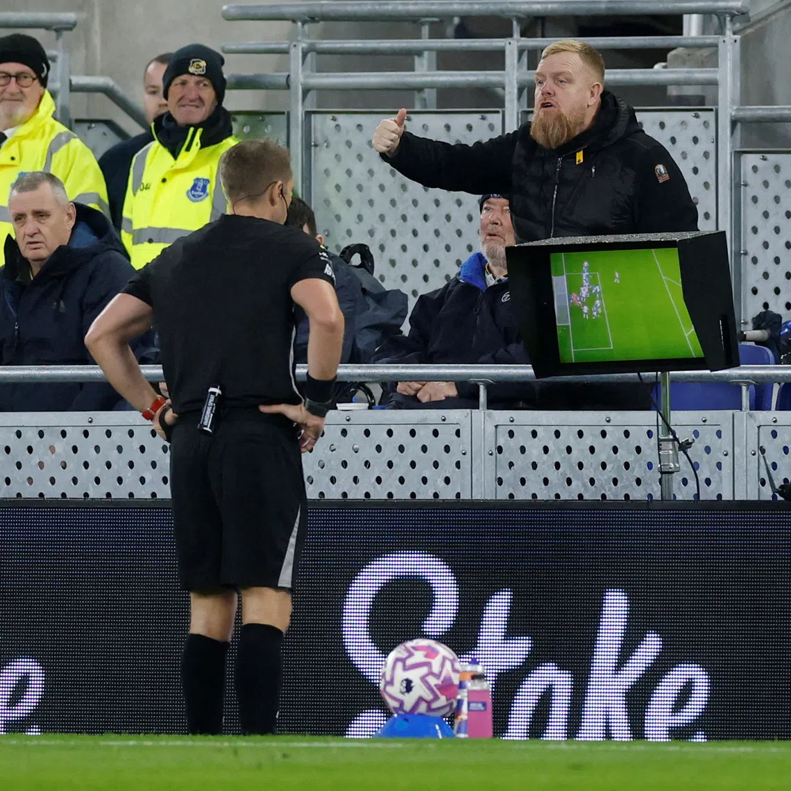 FILE PHOTO: Soccer Football - Premier League - Everton v Tottenham Hotspur - Hill Dickinson Stadium, Liverpool, Britain - October 26, 2025 Referee Craig Pawson checks the VAR screen before disallowing Everton's first goal scored by Everton's Jake O'Brien Action Images via Reuters/Jason Cairnduff/ File Photo