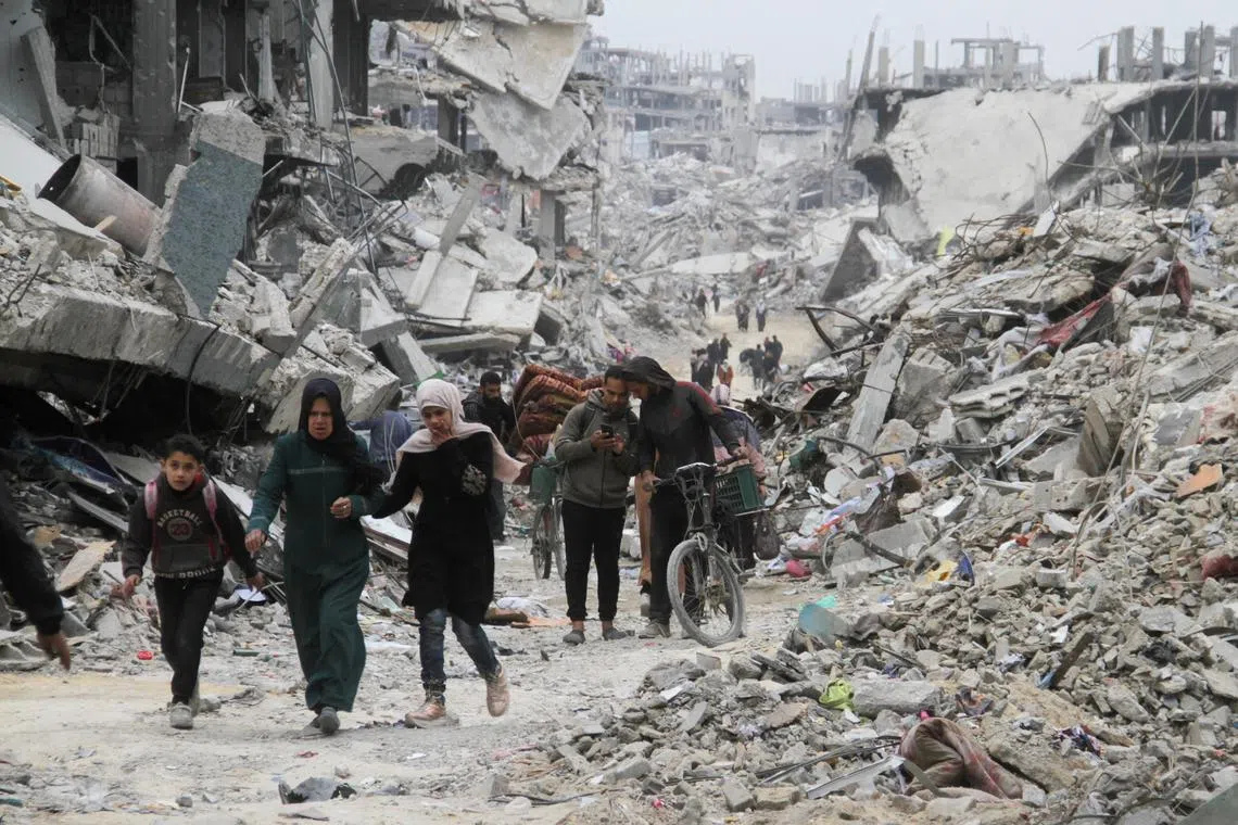 Palestinians walk past the rubble of buildings destroyed during the Israeli offensive, in Jabalia in the northern Gaza Strip, on Jan 22.
