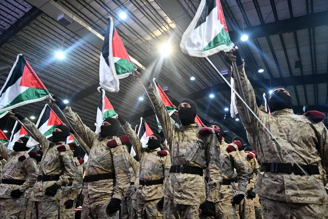 epa11260780 Hezbollah members stand in formation and hold up Palestinian flags during a gathering to commemorate Al Quds Day (Jerusalem Day) in a suburb of Beirut, Lebanon, 05 April 2024. Al Quds Day was declared in 1979 by the late Ayatollah Khomeini, founder of the Islamic Iranian Republic, who called on the world's Muslims to show solidarity with Palestinians on the last Friday of the fasting month of Ramadan.  EPA-EFE/WAEL HAMZEH