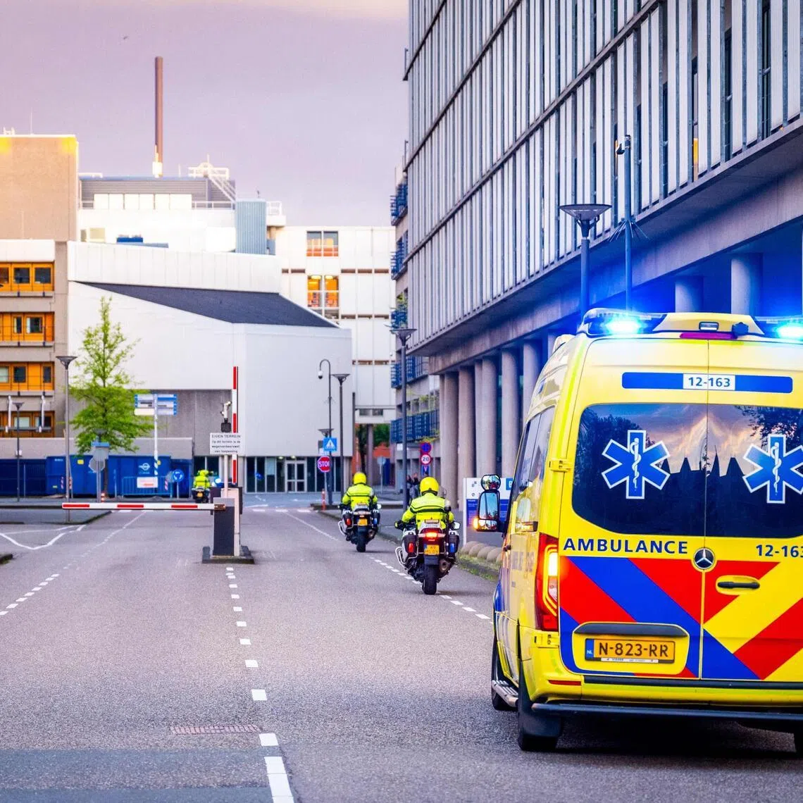 An ambulance part of a convoy allegedly carrying at least one of the passengers from the cruise ship MV Hondius believed to be infected with hantavirus escorted by Dutch police on motorcycles as it arrives near Leiden University Medical Center.