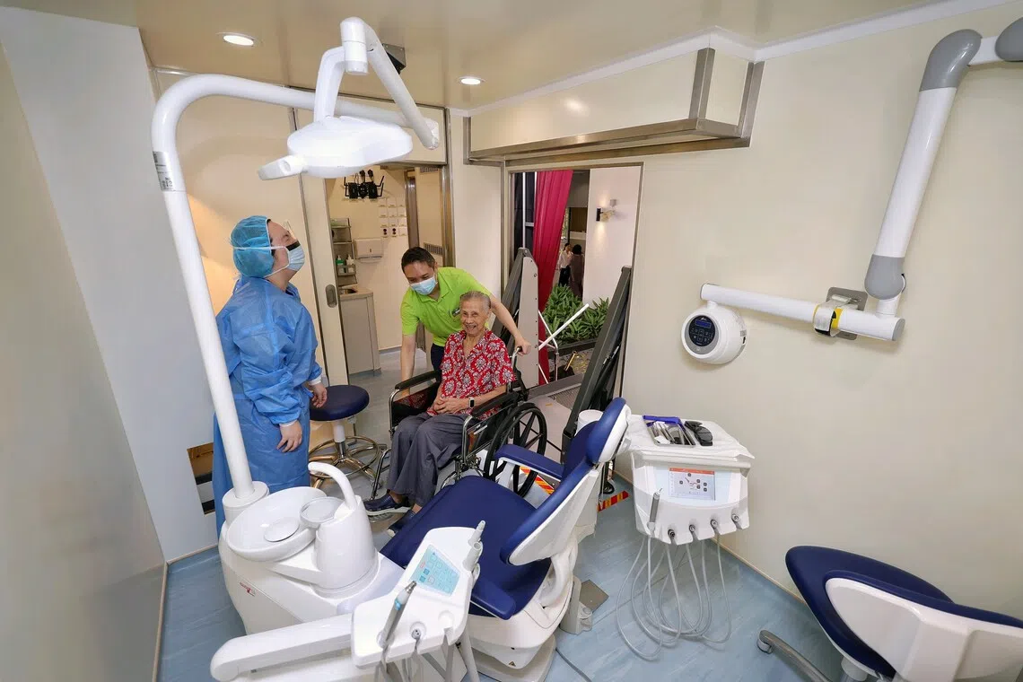 Madam Toh Yeow Leng being assisted up via a ramp and into the mobile dental clinic at Bright Hill Evergreen Home on Sept 26.