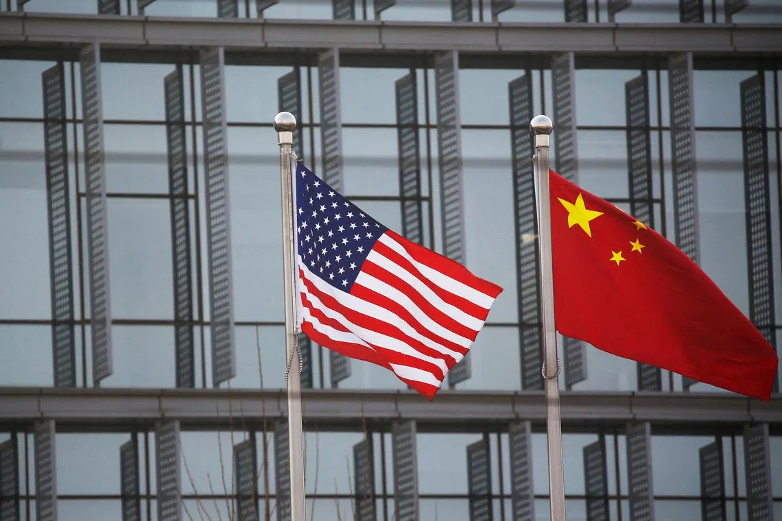 FILE PHOTO: Chinese and U.S. flags flutter outside the building of an American company in Beijing, China, January 21, 2021. REUTERS/Tingshu Wang/File Photo