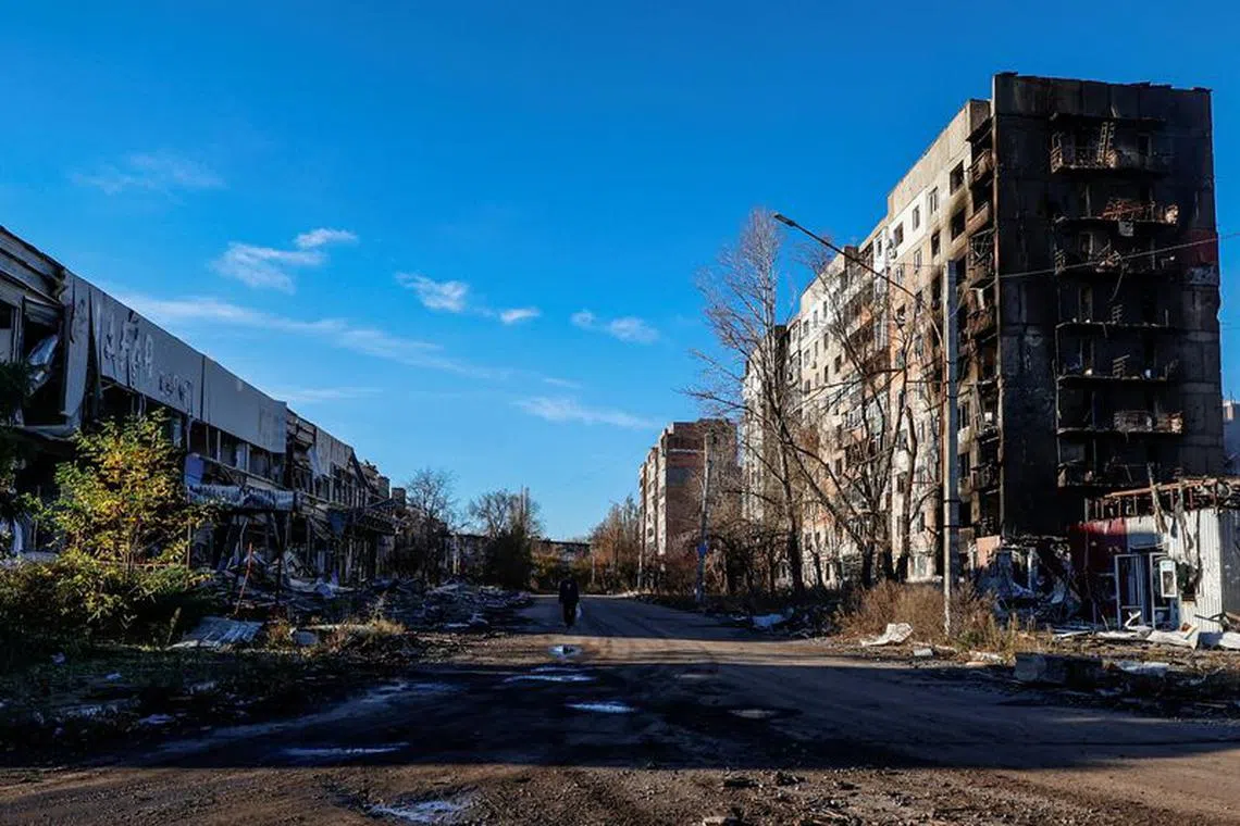 FILE PHOTO: A local resident walks next to residential buildings heavily damaged by Russian military strikes in the front line town of Avdiivka, amid Russia's attack on Ukraine, in Donetsk region, Ukraine November 8, 2023. Radio Free Europe/Radio Liberty/Serhii Nuzhnenko via REUTERS/File Photo