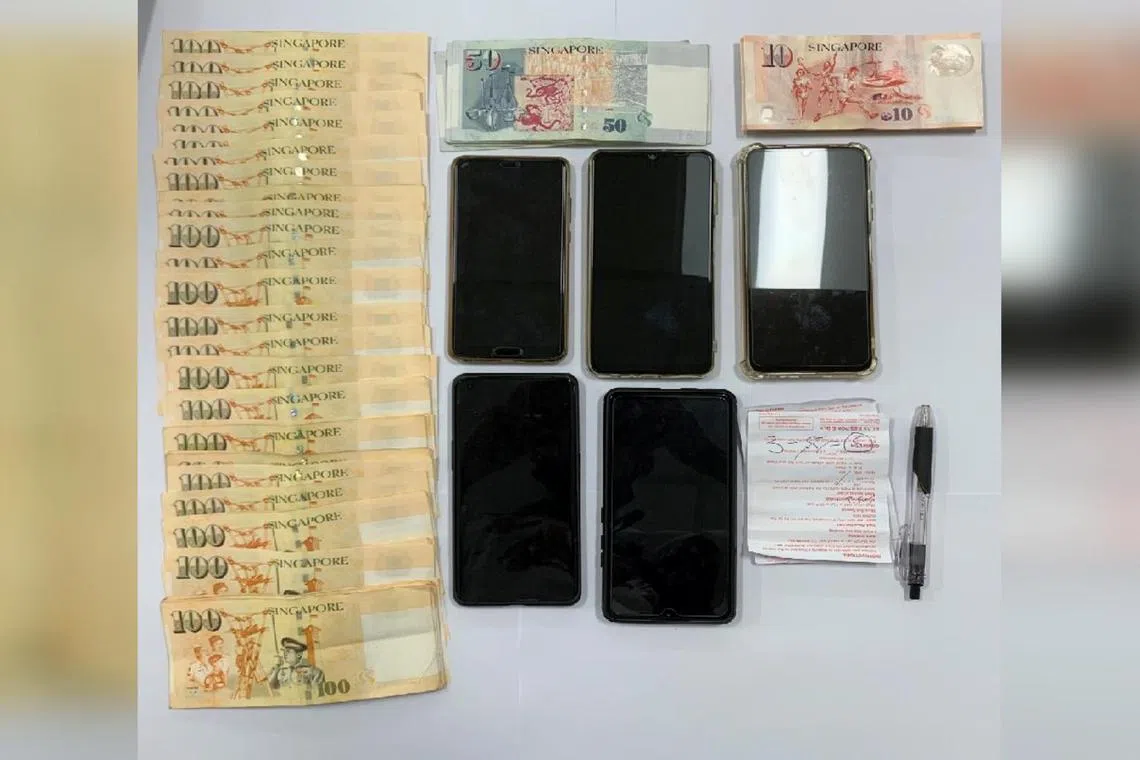 Cash, mobile phones and gaming-related paraphernalia seized by the police during a raid in Woodlands on Nov 26, 2022.