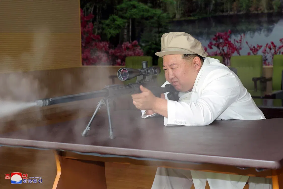 North Korean leader Kim Jong Un trying a weapon during an inspection of major munitions factories at an undisclosed location in North Korea.