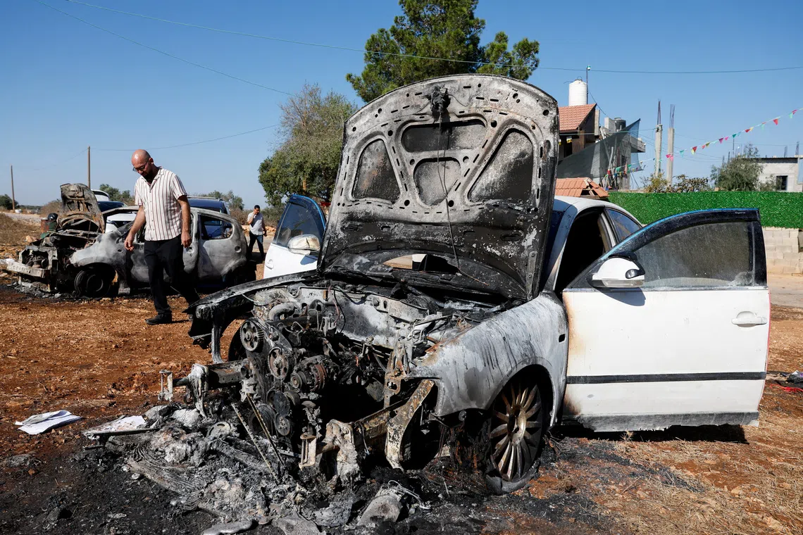 A man walks past destroyed cars, which Palestinians say were burned by Israeli settlers last night, in Beita, near Nablus, in the Israeli-occupied West Bank, September 2, 2026. REUTERS/Mohammed Torokman