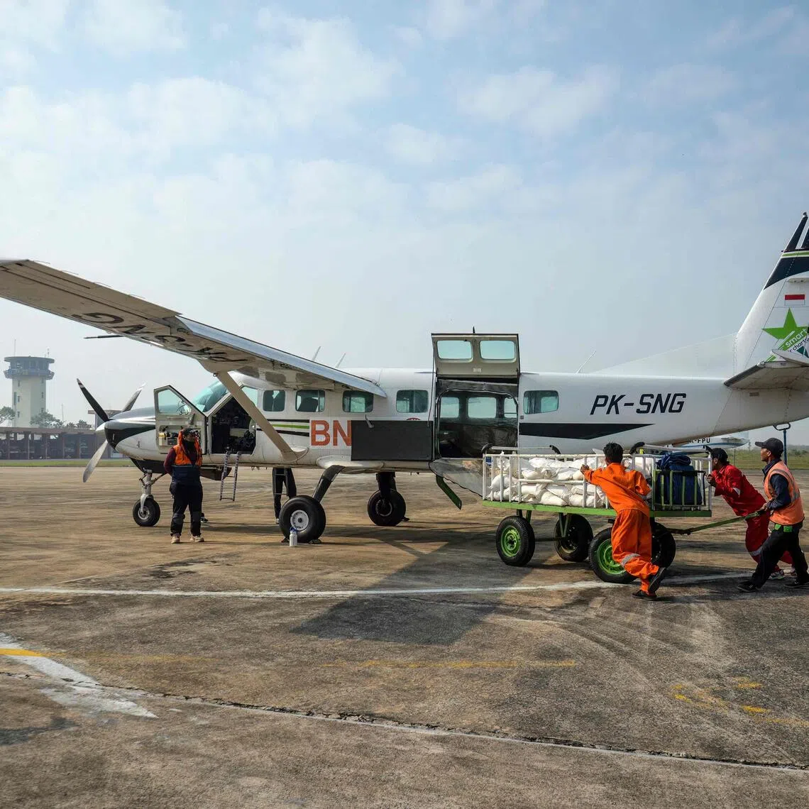 National Disaster Management Agency personnel loading sodium chloride into an aircraft before a cloud seeding mission at Tjilik Riwut Airport in Palangkaraya, central Kalimantan.