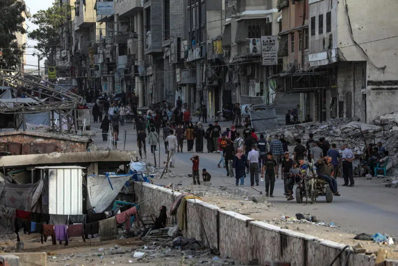 Palestinians walk at Al Remal neighbourhood during an Israeli military operation in Gaza City on Oct 5.