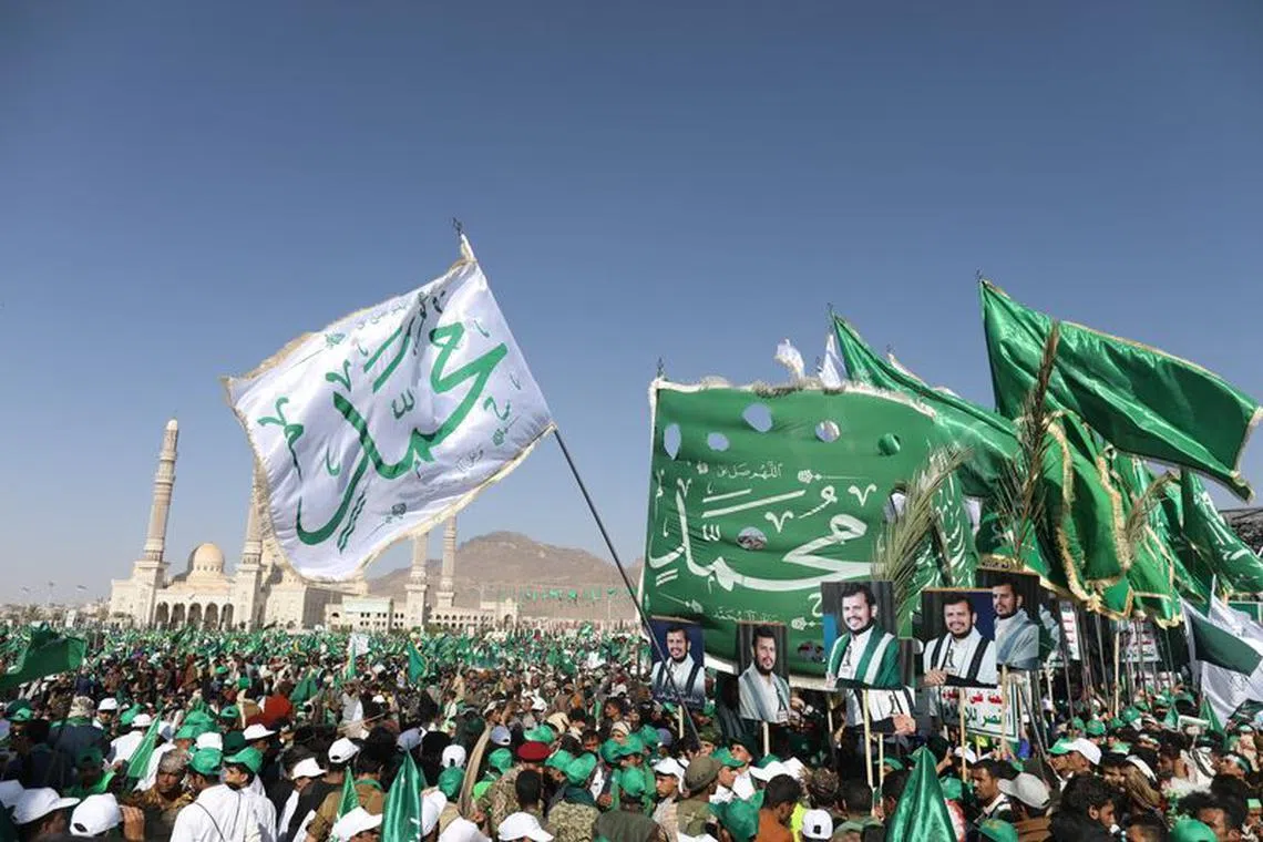 Houthi supporters hold up flags and posters of the Houthi leader Abdul-Malik Badruddin al-Houthi during a rally to mark the Prophet Muhammad's birthday in Sanaa, Yemen October 18, 2021. REUTERS/Khaled Abdullah/File Photo