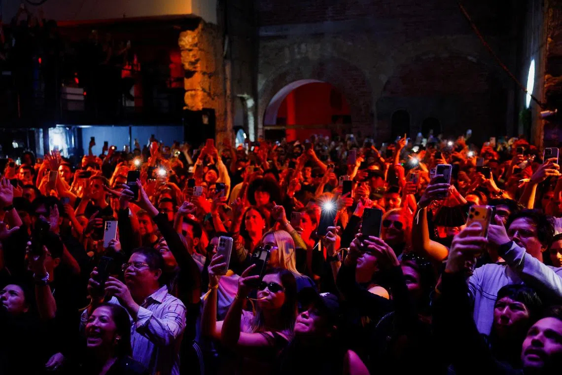 People dance and use their cell phones in Mexico on Dec 14, 2025. 