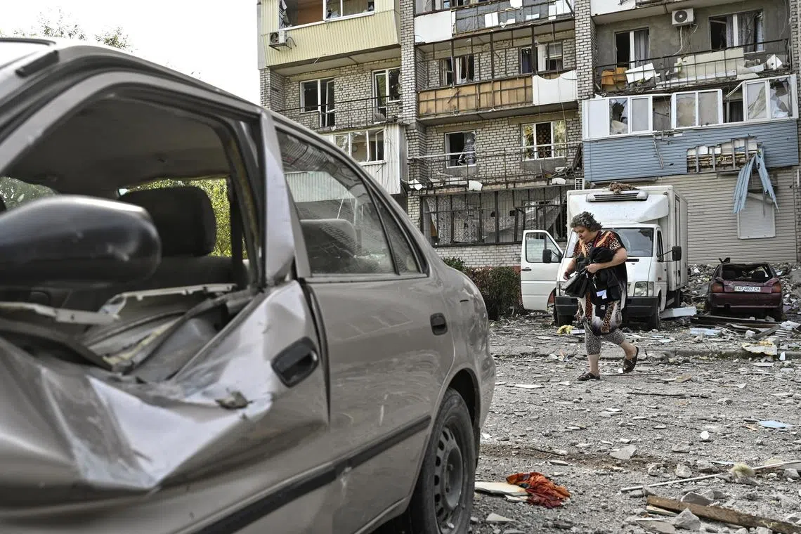 A woman walking near to her apartment building - damaged by a Russian air strike - in the Ukrainian city of Zaporizhzhia, on Oct 1.