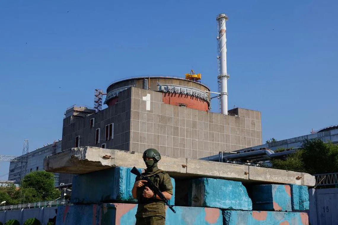 FILE PHOTO: A Russian service member stands guard at a checkpoint near the Zaporizhzhia Nuclear Power Plant before the arrival of the International Atomic Energy Agency (IAEA) expert mission in the course of Russia-Ukraine conflict outside Enerhodar in the Zaporizhzhia region, Russian-controlled Ukraine, June 15, 2023. REUTERS/Alexander Ermochenko/File Photo