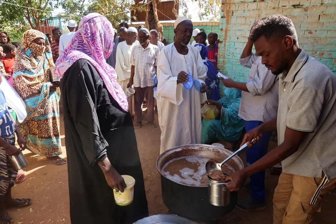 FILE PHOTO: Volunteers distribute food to residents and displaced people in Omdurman, Sudan, March 8, 2024. Nearly five million people in the country are close to famine as Sudan's civil war passes the one-year mark. REUTERS/El Tayeb Siddig/File Photo