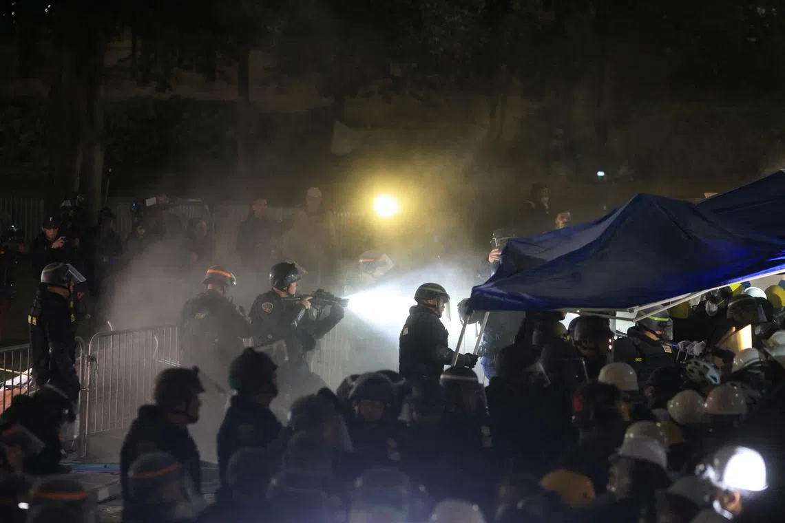 Police officers in riot gear enter a pro-Palestinian encampment at the University of California, Los Angeles.