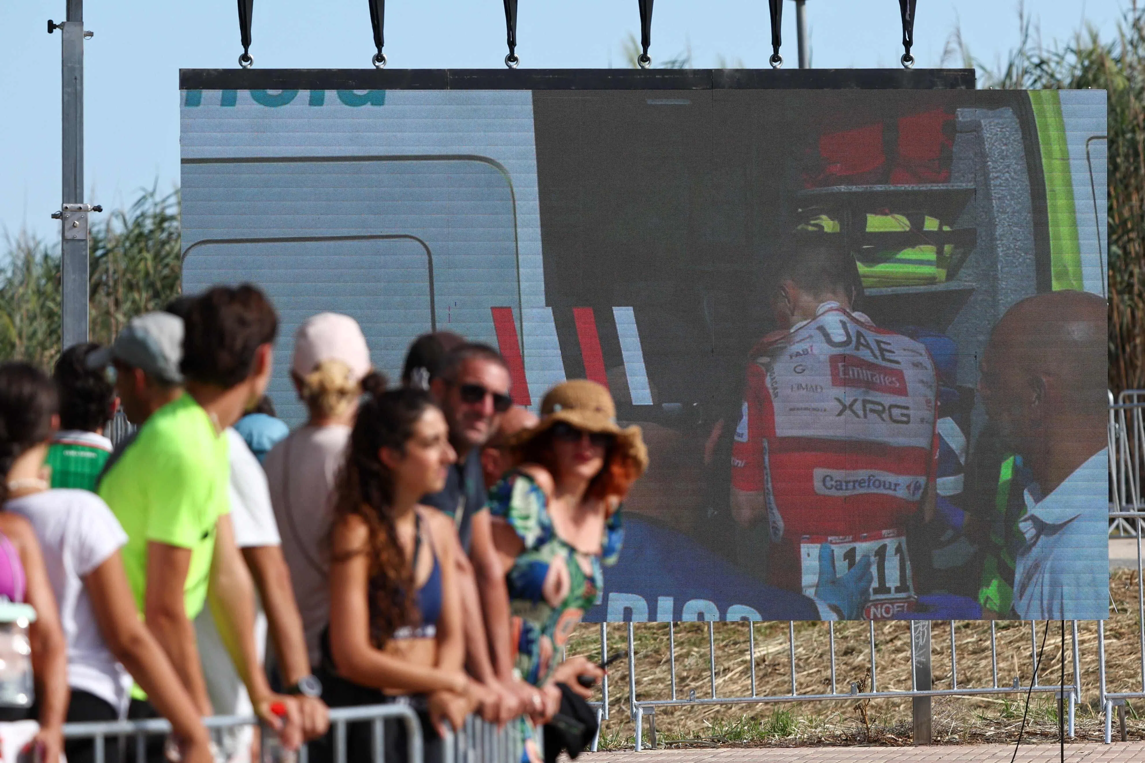 Team UAE’s Tadej Pogacar is seen on a giant screen entering an ambulance after crashing on Aug 29 in the Vuelta a Espana.