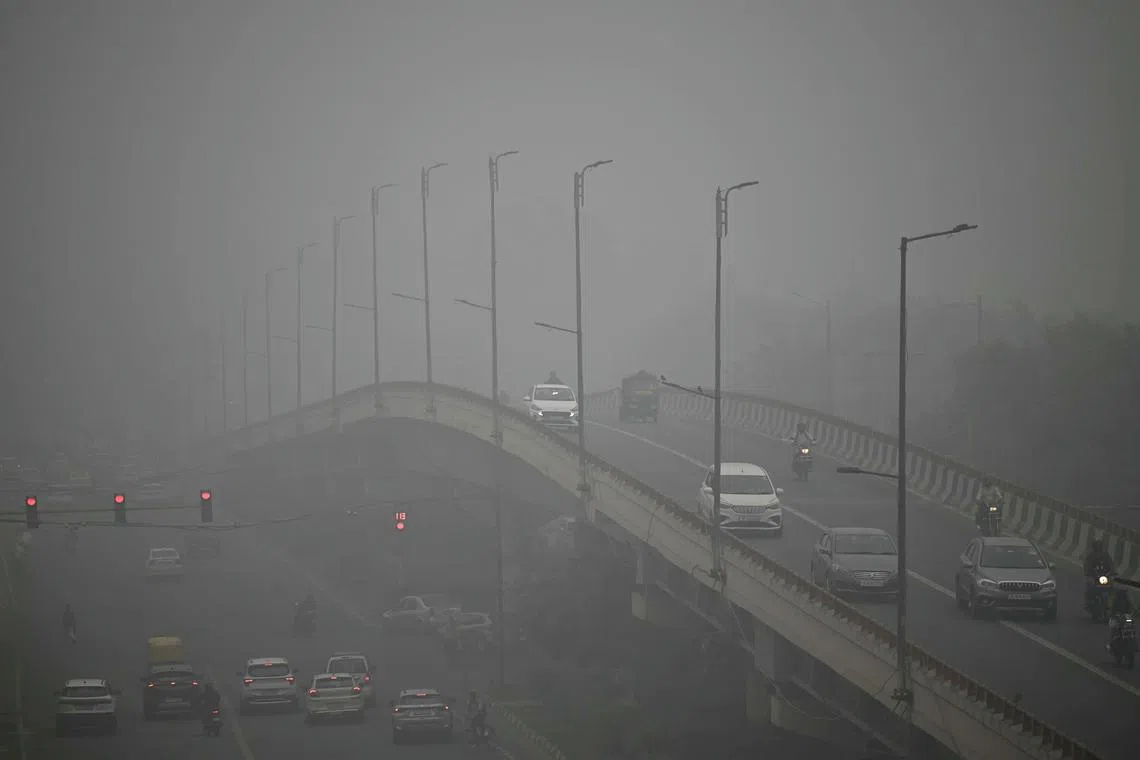 Commuters drive amid dense smog in New Delhi on Nov 13. India's capital New Delhi was wreathed in blanketing toxic smog. 