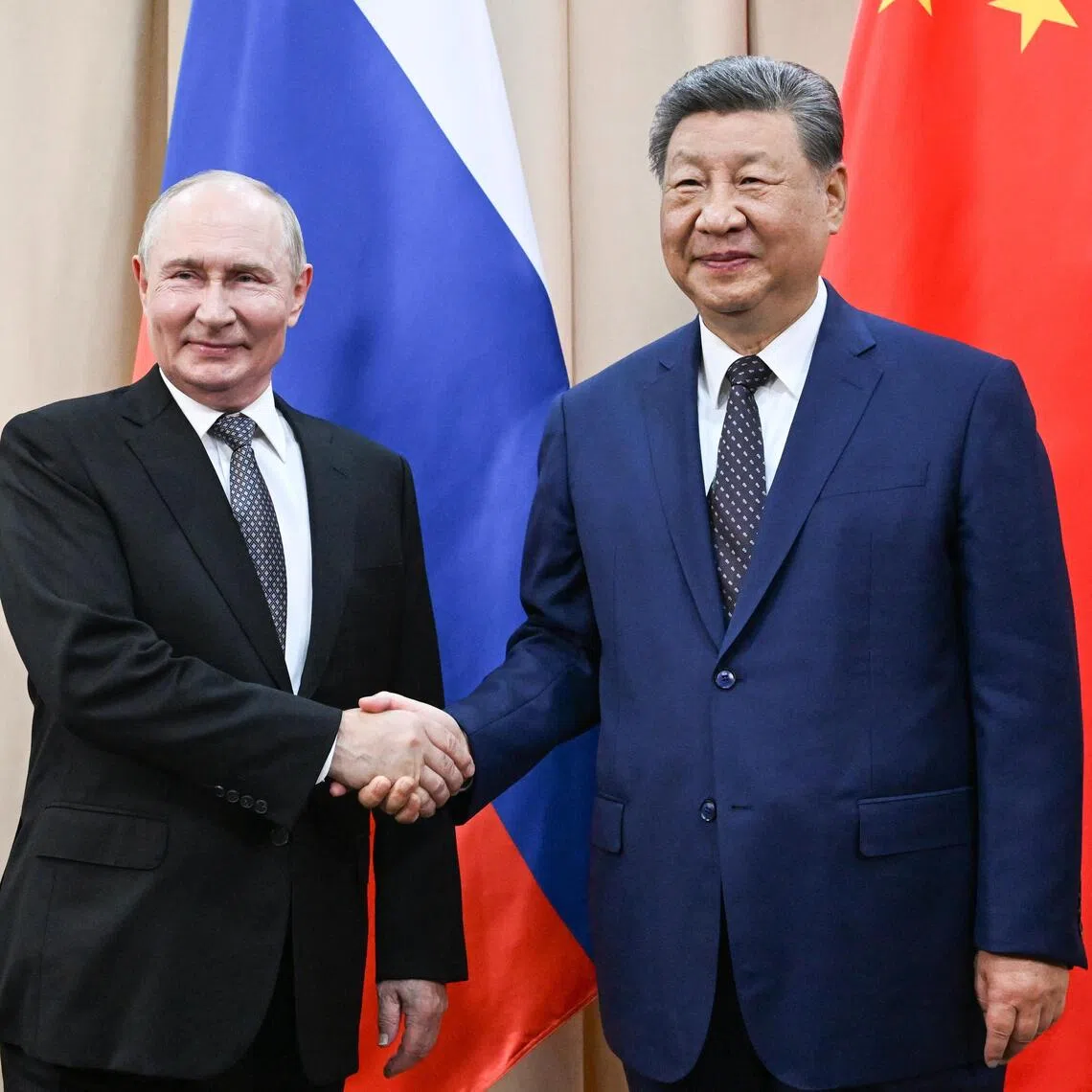 Russian President Vladimir Putin (left) and Chinese President Xi Jinping shaking hands on the sidelines of the Shanghai Cooperation Organisation summit in Bishkek, Kyrgyzstan, on Aug 31.
