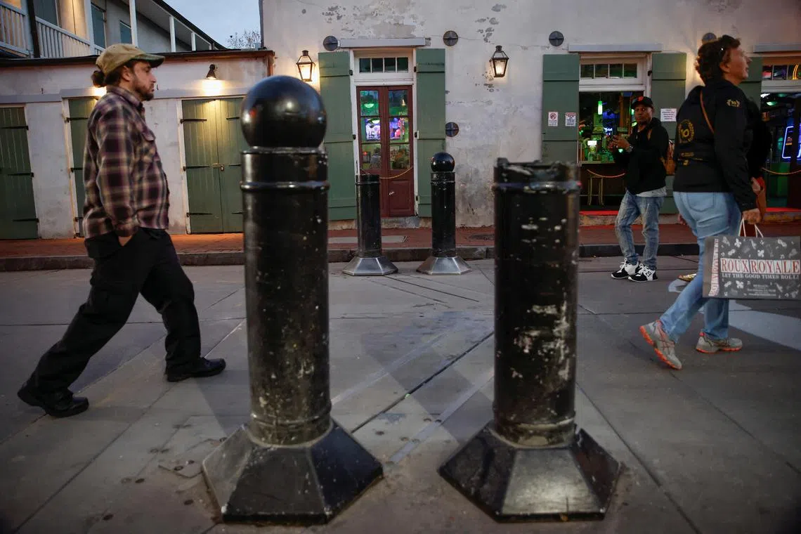 People on Jan 2 walking near older models of traffic bollards, which the city plans to replace, after 14 people were killed by a man driving a truck in an attack during New Year's celebrations in New Orleans. 