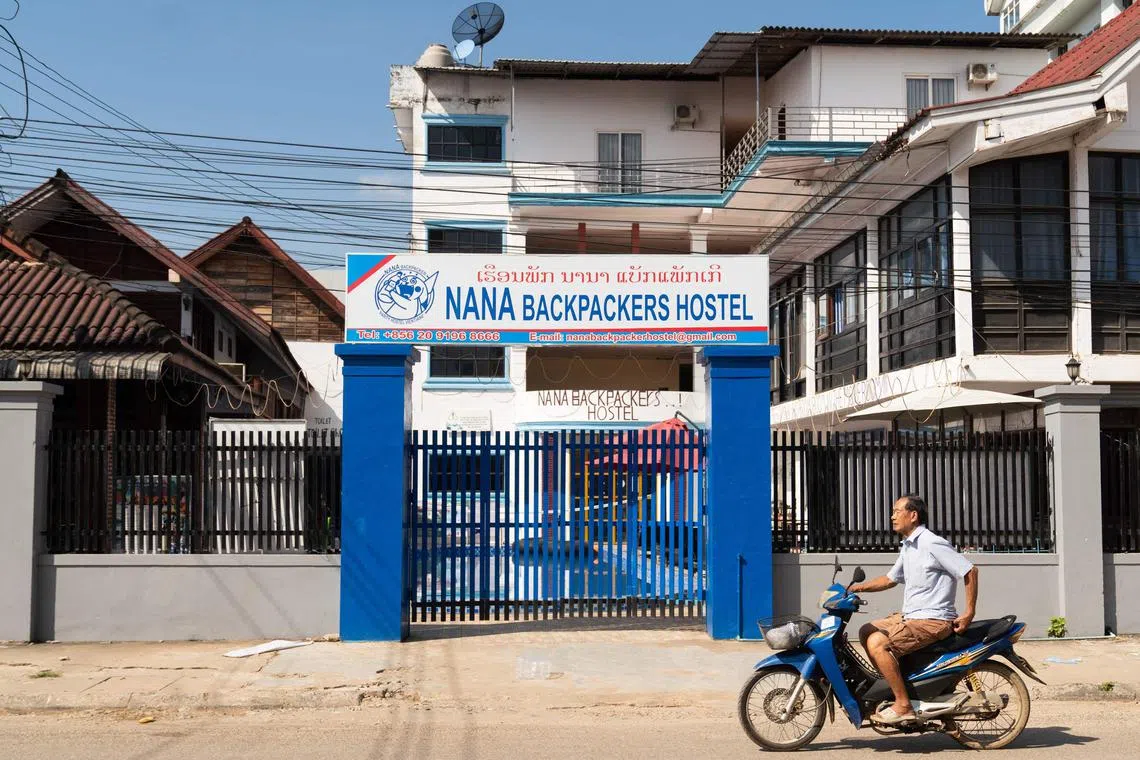 TOPSHOT - A motorcyclist passes the Nana Backpackers Hostel in Vang Vieng on November 24, 2024. The Laos government said on November 23 it was "profoundly saddened" by the deaths of foreign tourists in Vang Vieng, with the toll from a suspected methanol poisoning incident now at six. Six tourists died of suspected methanol poisoning after a night out in the Laos backpacker hotspot of Vang Vieng last week. (Photo by AFP)