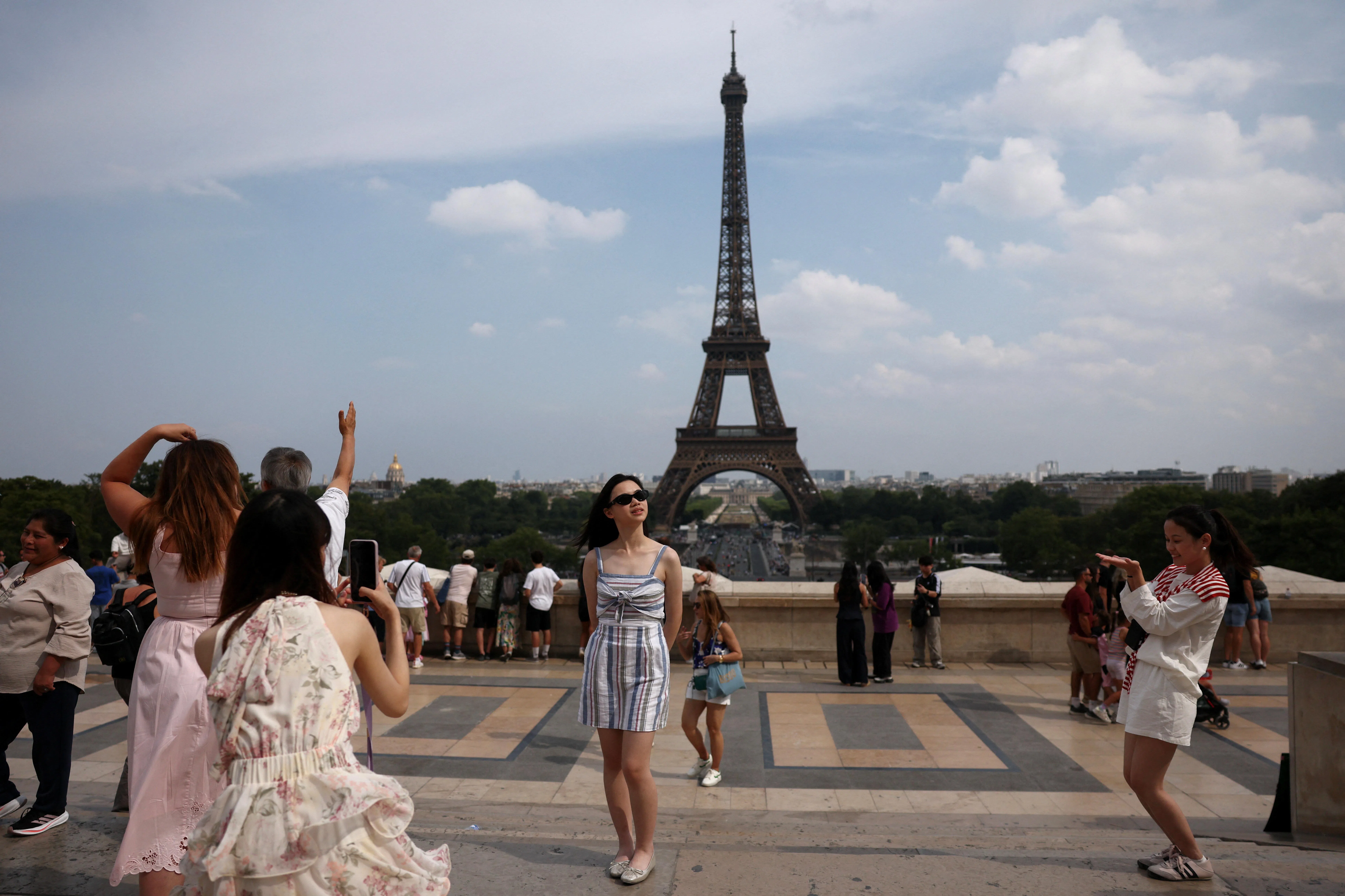 Tourists posing for photos at Trocadero square in Paris, France.