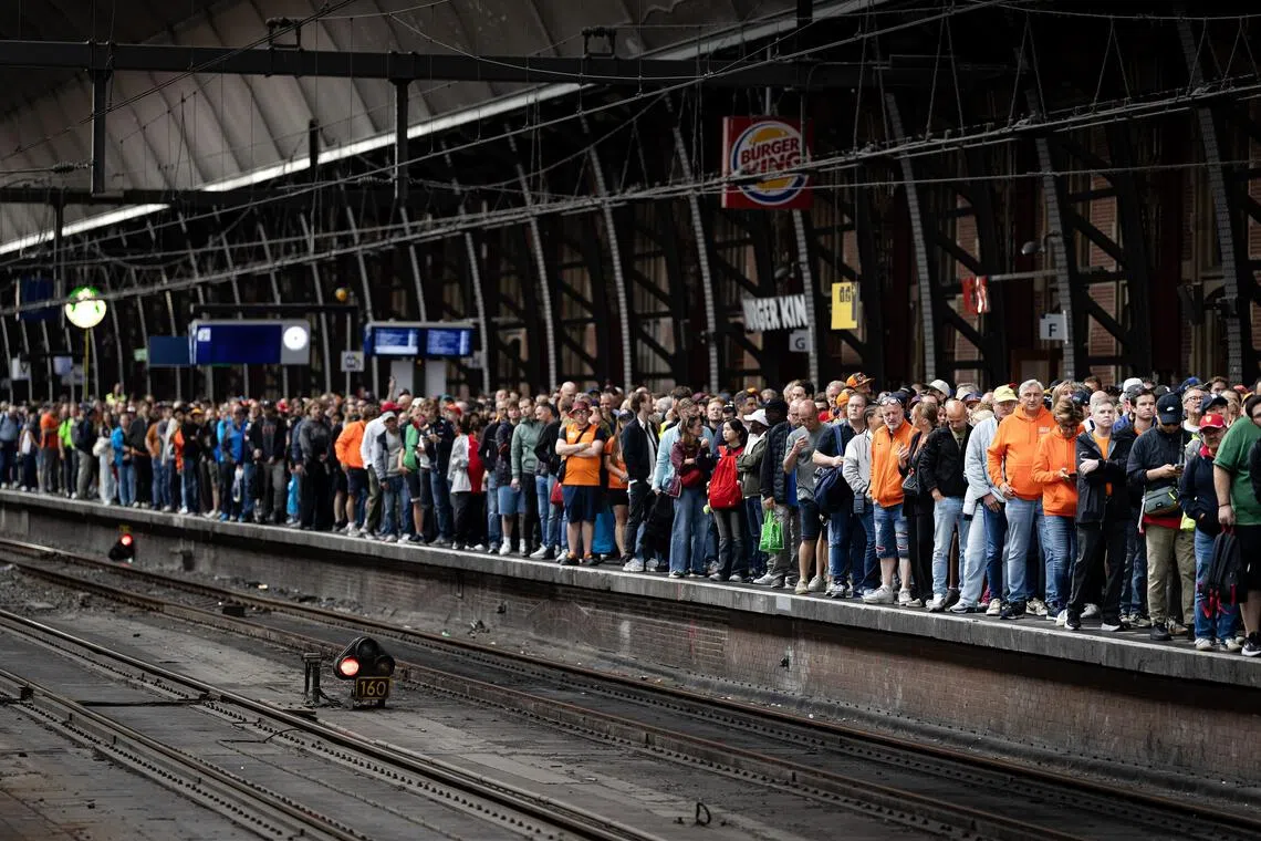 Race fans at Central Station in Amsterdam, on Aug 22, to travel by train to Zandvoort on the day of the sprint race and qualifying preceding the F1 Dutch Grand Prix.