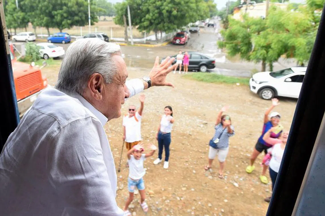 Mexican President Andres Manuel Lopez Obrador waves as he travels from Oaxaca to Veracruz on board the \"Tren Transistmico\" passenger train during its first test trip, in southern Mexico September 17, 2023. Mexico Presidency/Handout via REUTERS