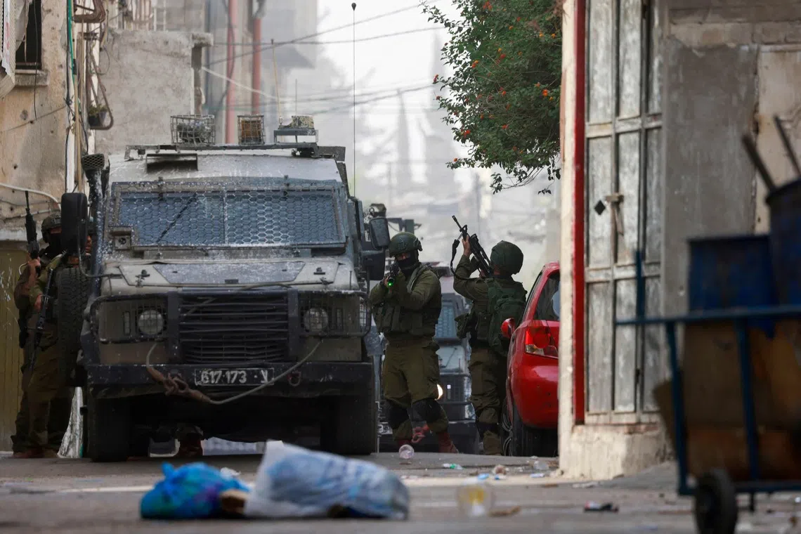 An Israeli soldier aims his weapon during a raid at the Balata refugee camp east of Nablus city in the occupied West Bank, on Aug 11.