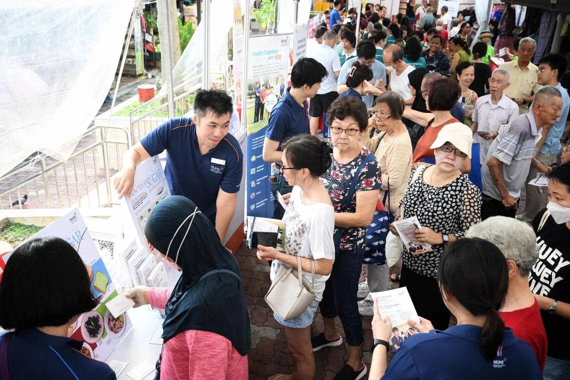 Residents queuing up to visit the booths at the Health Together carnival in Teck Whye on May 11.
