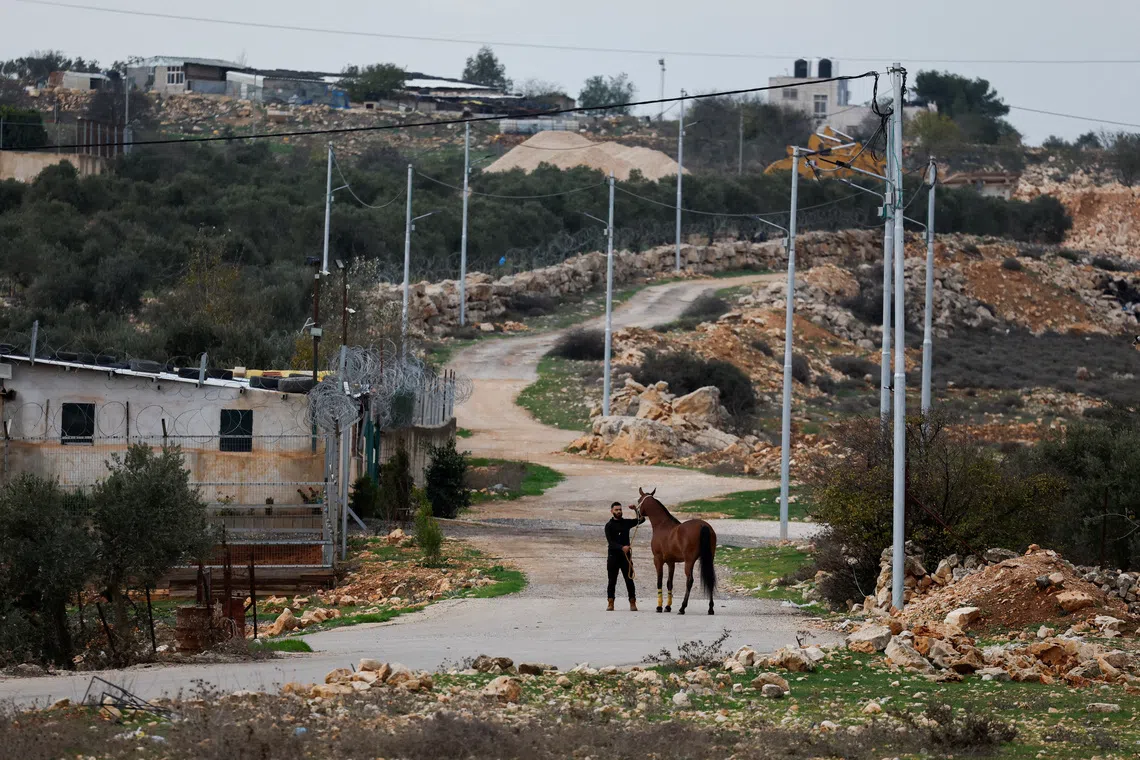 A Palestinian man stands with his horse in the Palestinian village of Deir Dibwan, in the Israeli-occupied West Bank, on Dec 13.