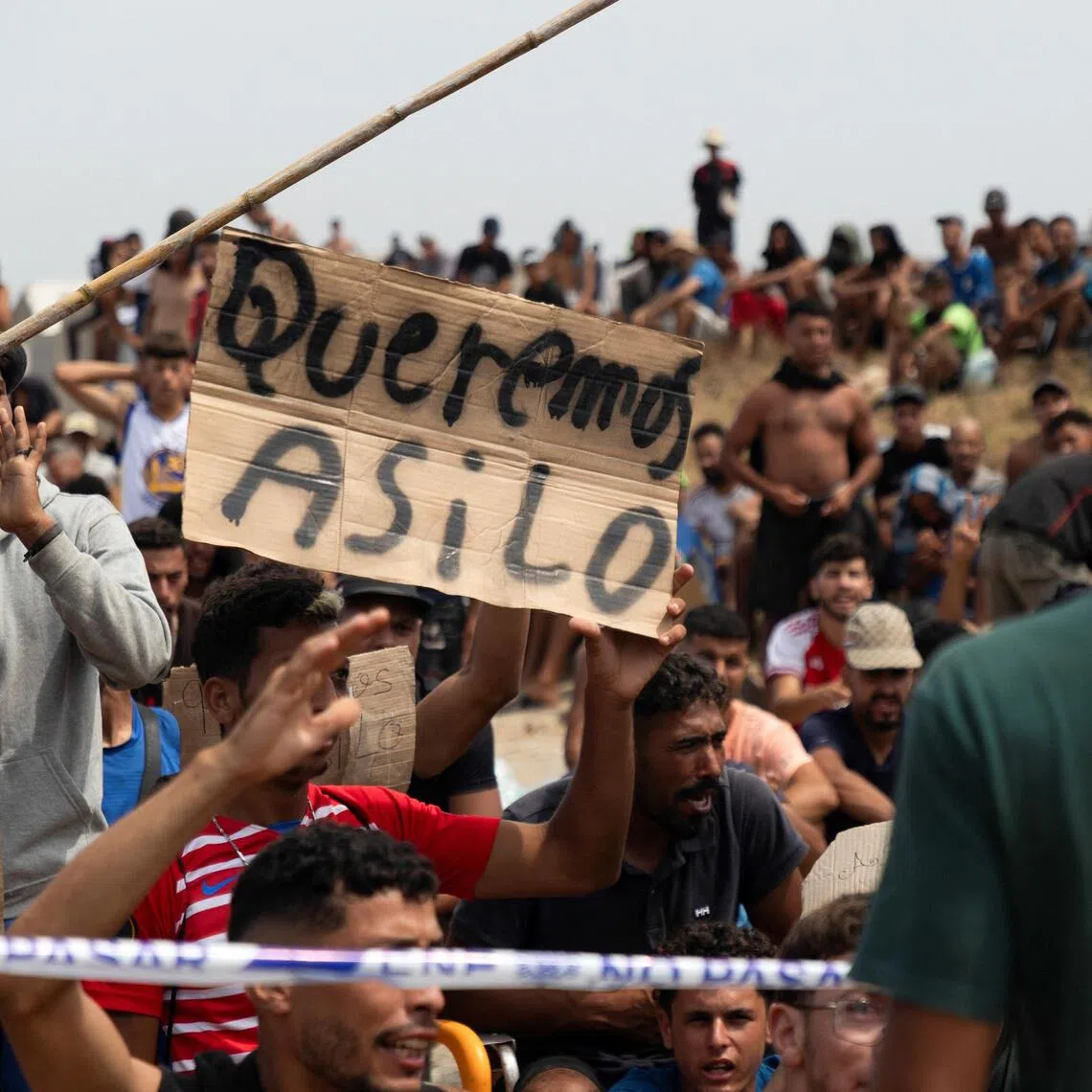 A migrant holding a sign reading “We want asylum”, in Spanish, on Aug 16, in Spain’s north African enclave of Ceuta.