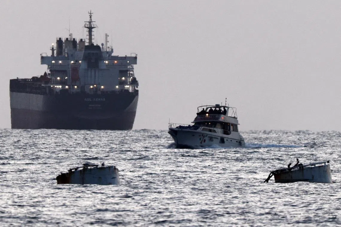Israeli soldiers are seen on a vessel bearing symbols of the Global Sumud Flotilla, with a cargo ship behind it, as seen from Ashdod, southern Israel, May 19, 2026. REUTERS/Amir Cohen