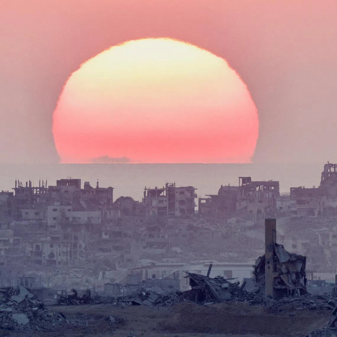 The sun sets over north Gaza, as seen from the Israeli side of the border, July 28, 2025. REUTERS/Amir Cohen