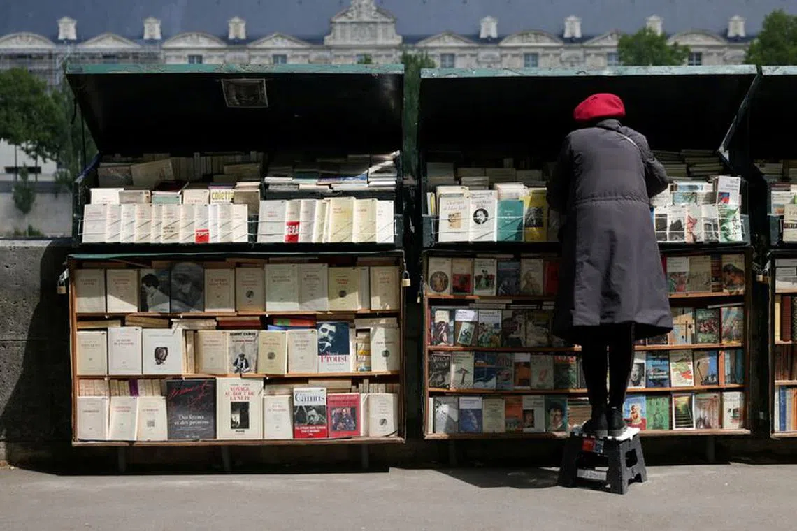 FILE PHOTO: A book seller prepares her stall along the edge of The Seine in Paris, France, May 30, 2022.  REUTERS/Kevin Coombs/File Photo