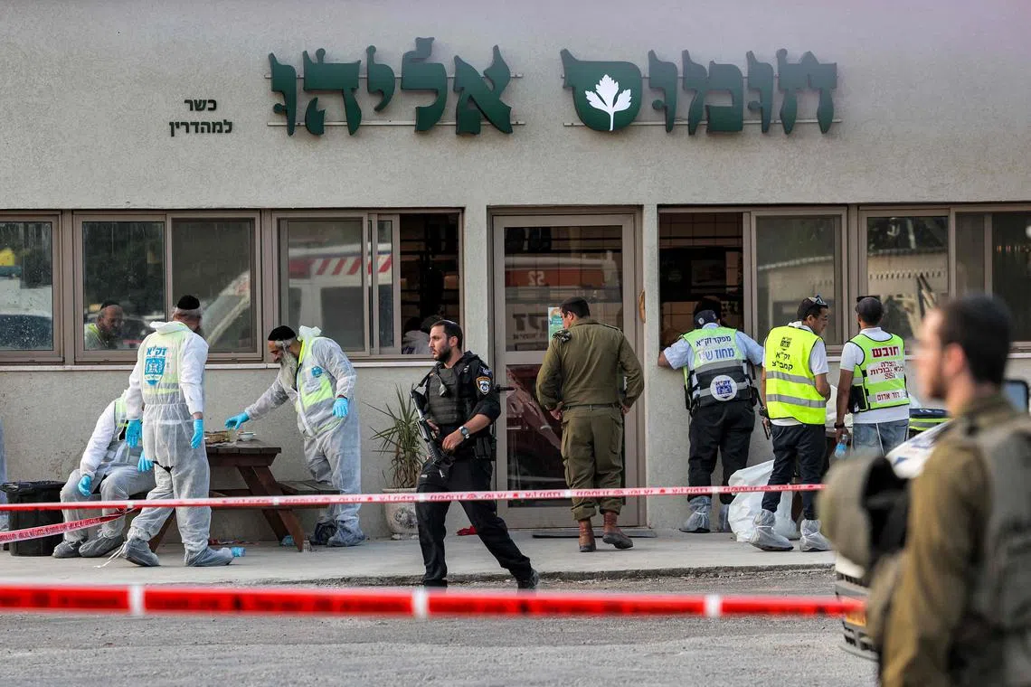 Israeli forensics experts inspect the scene of the attack, outside a restaurant near the Jewish settlement of Eli.