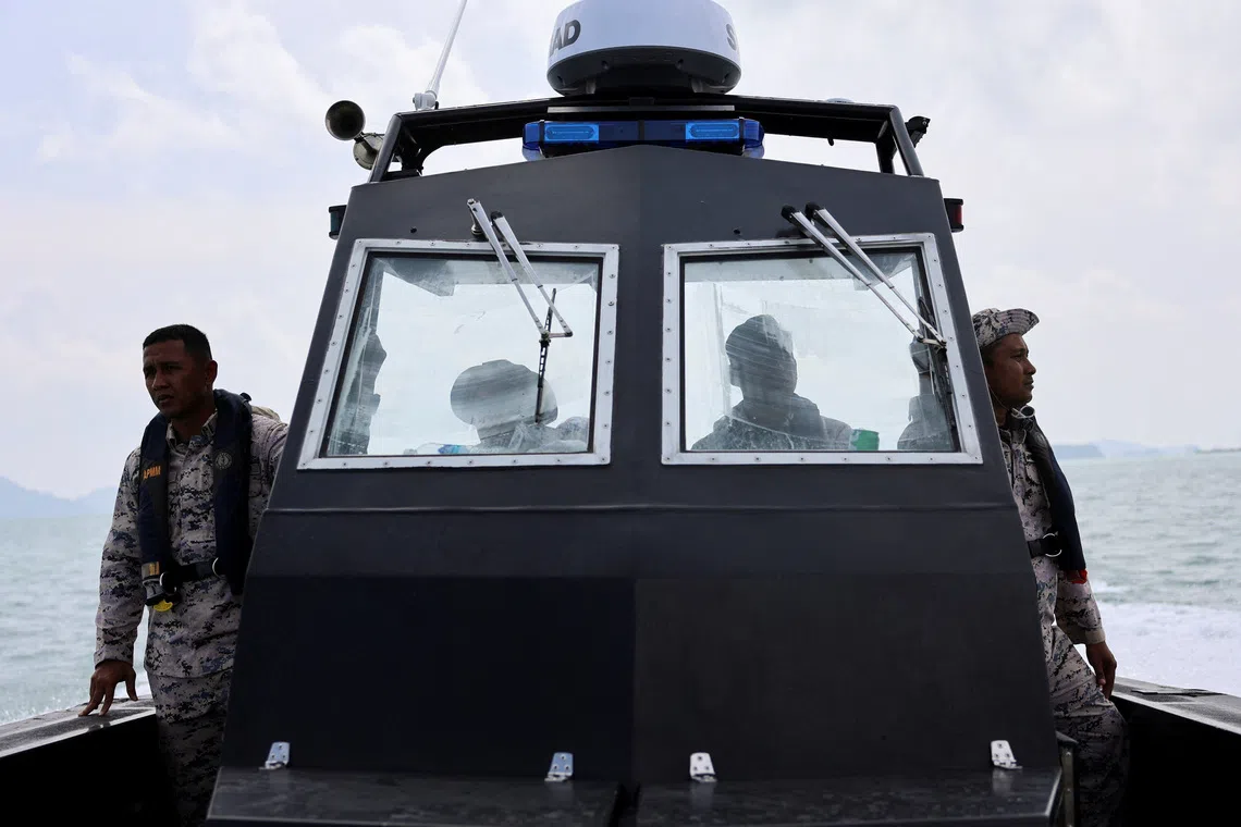 Malaysian Maritime Enforcement Agency officers search for victims during a search and rescue operation.