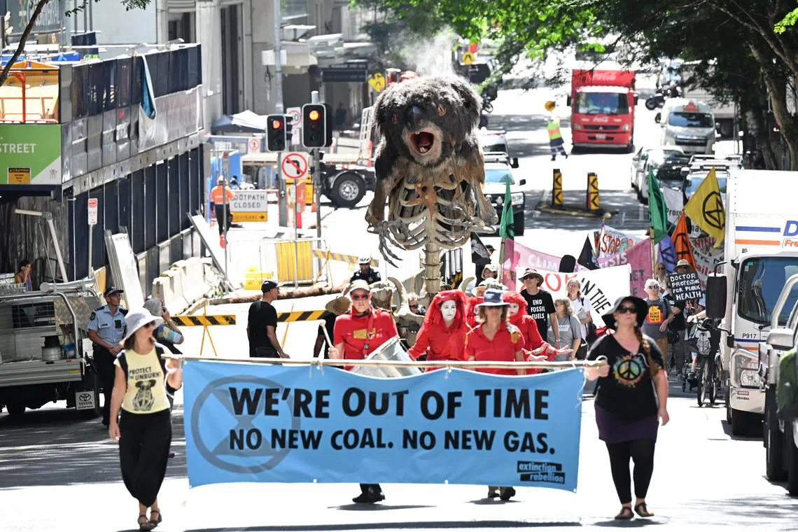 epa10525033 Extinction Rebellion protesters push a giant animatronic puppet depicting a burning Koala called 'Blinky' through the streets of the central business district (CBD) in Brisbane, Queensland, Australia, 15 March 2023. Extinction Rebellion (XR) environmental activists marched through the CBD of Brisbane to protest against the fossil fuel industry.  EPA-EFE/DARREN ENGLAND AUSTRALIA AND NEW ZEALAND OUT